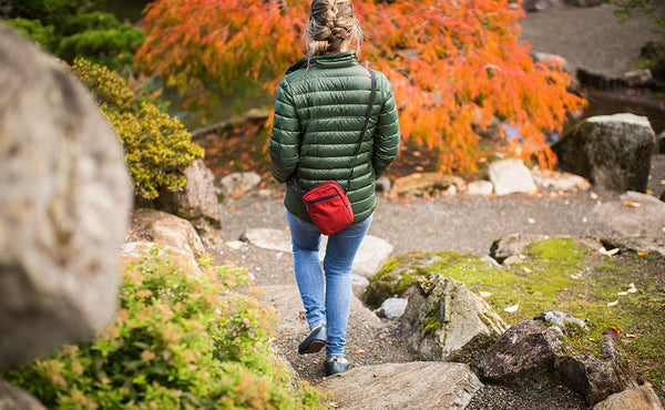 Person wearing a Everyday Cubelet in Mars Red at a Japanese garden. Walking down steps to a pond.